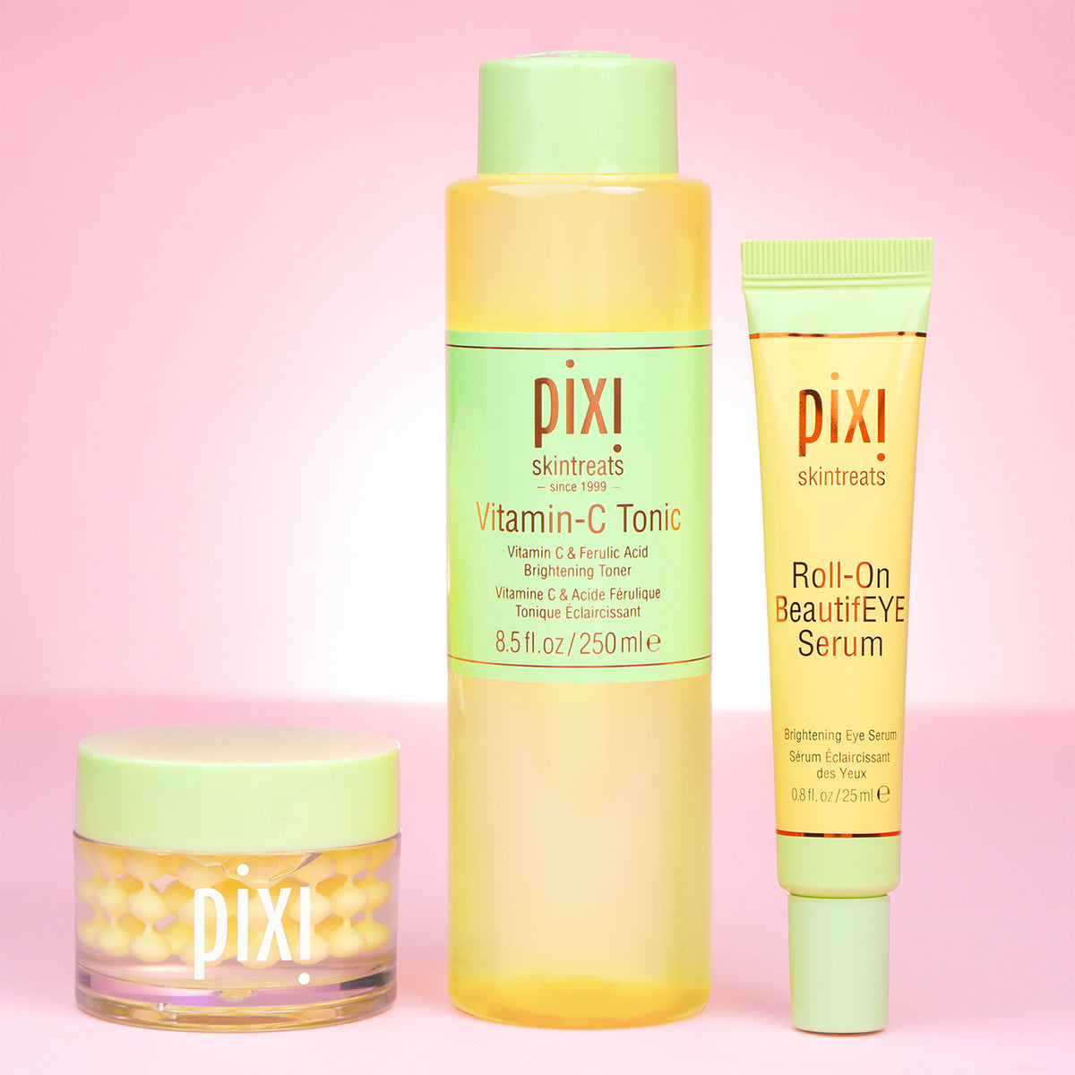 Pixi skincare products including Vitamin-C CreamSerum, Vitamin-C Tonic and Roll-on BeautifEYE Serum for eyes on a pink background