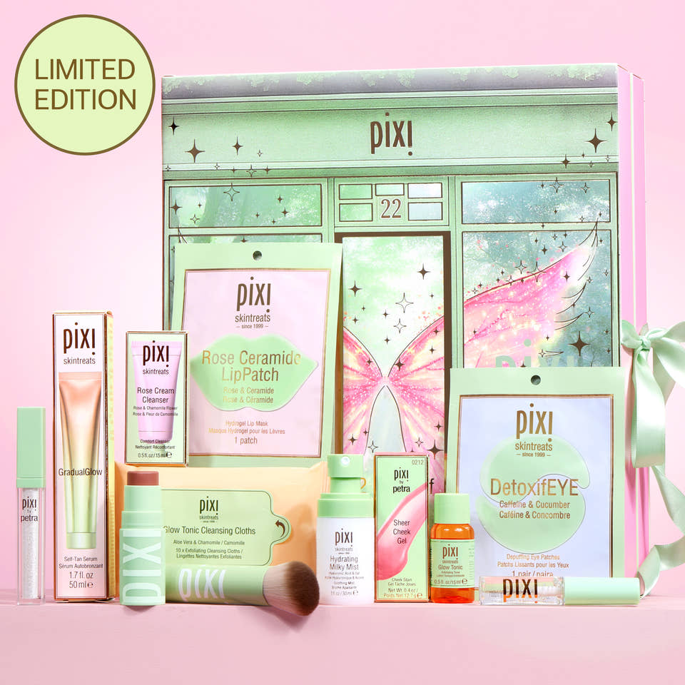 Pixi Advent Calendar set on a pink background, featuring a mint green fairy-themed box with multiple skincare products including lip patch, eye cream, cleanser, and toner. view 1